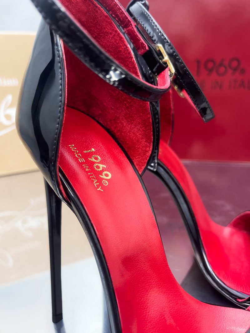 Close-up of black patent leather stiletto sandals featuring red insoles and gold 1969 Made in Italy branding.