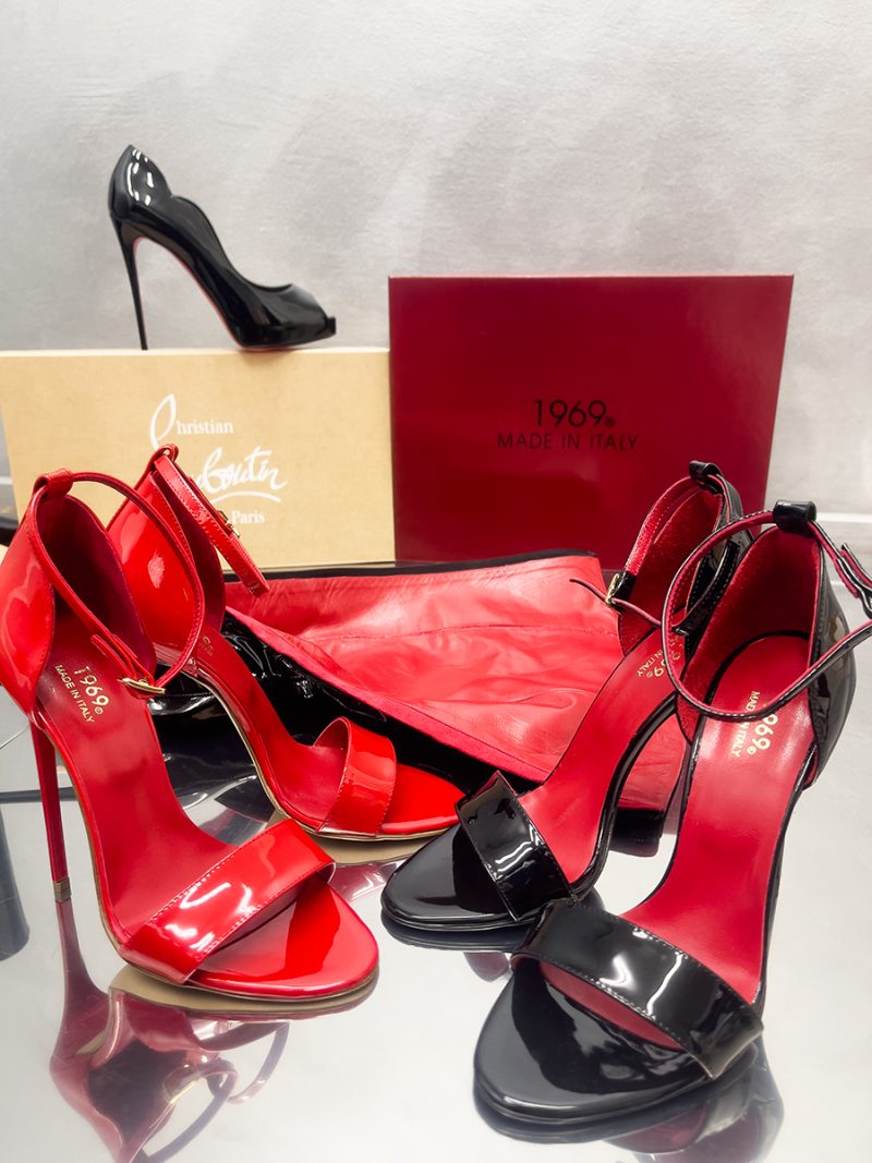 Display of red and black patent leather stiletto sandals next to a 1969 Made in Italy luxury shoe box.