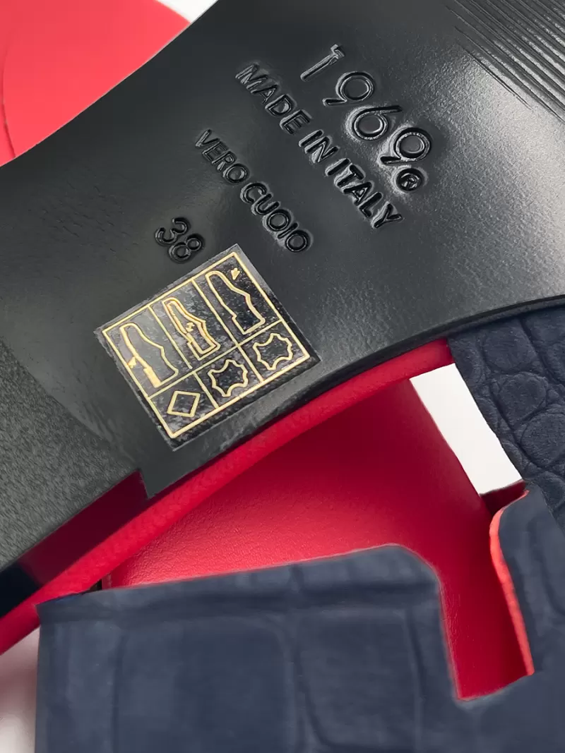 Close-up of dark blue croc suede flat sandal sole showing Vero Cuoio genuine leather stamp and size 38.