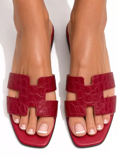 1969 Made in Italy red croc-embossed leather flat sandals with H-cut straps, worn on foot.